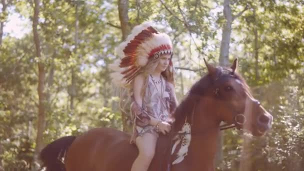 Young Woman In Headdress Riding Horse In Sunlit Forest — Stockvideo