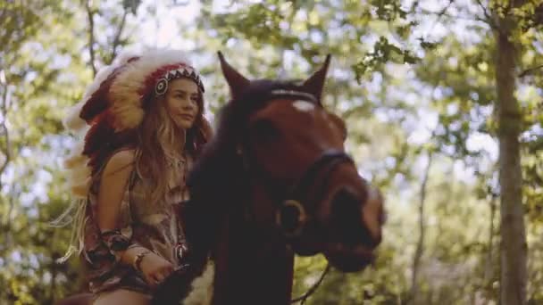 Woman In Headdress Riding Horse Through Sunlit Forest — Stockvideo