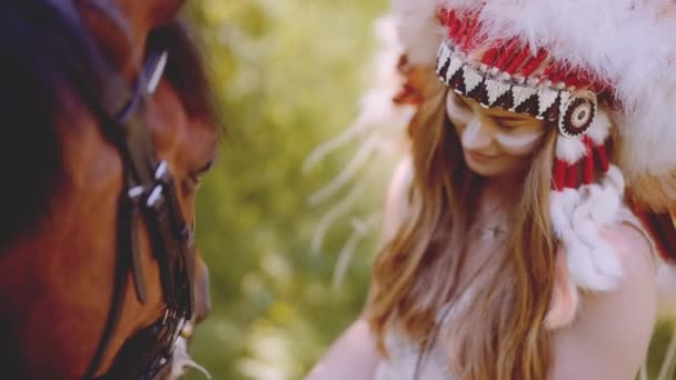 Жінка в головній убір годування з конем — стокове відео