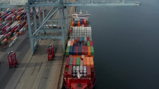 Top a Container Ship, Tower Crane, Forklifts, and the Calm Sea Waters — Stok Video