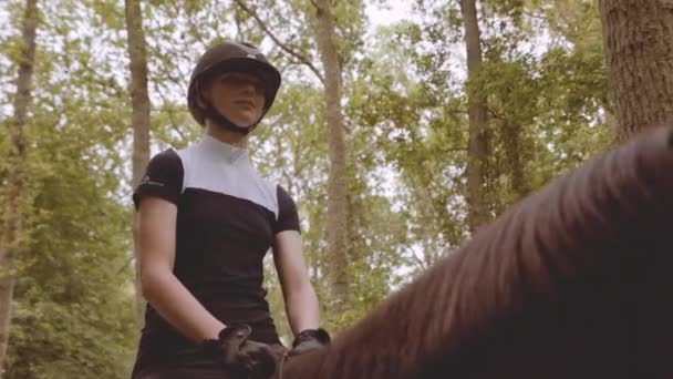 Junge Reiterin auf Pferd mitten im Wald in Zeitlupe — Stockvideo