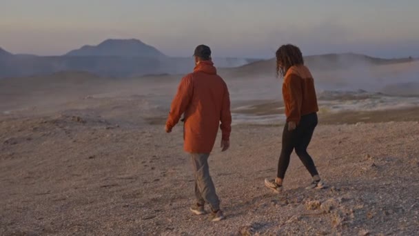 Turisti che camminano in un campo geotermico in Islanda sotto i cieli azzurri pallidi — Video Stock