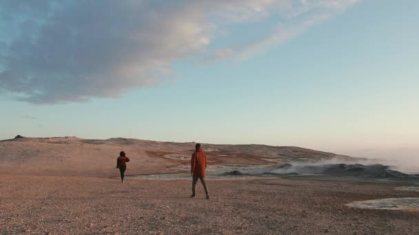 Paar spaziert durch ein geothermisches Land mit Blick auf den strahlend blauen Himmel — Stockvideo