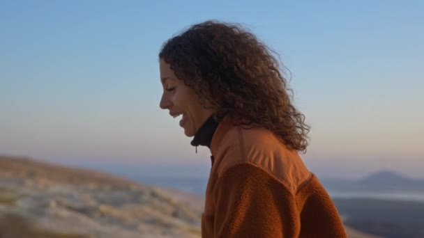 Hermosa modelo femenina caminando en un campo geotérmico bajo los cielos del atardecer — Vídeos de Stock