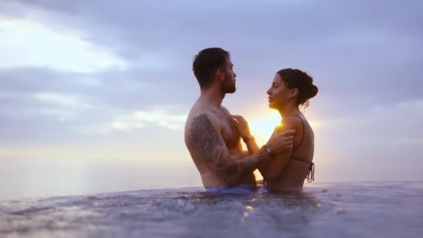 Pareja de pie cerca el uno del otro en una piscina infinita — Vídeo de stock