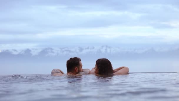 Casal olhando um para o outro com a vista das montanhas cobertas de neve — Vídeo de Stock