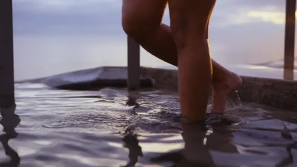 Vacker kvinna störta på oändlighet pool med panorama av gyllene solnedgång — Stockvideo