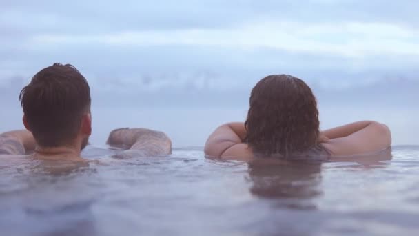 Casal com a vista das montanhas com neve em seu pico sob céus azuis — Vídeo de Stock