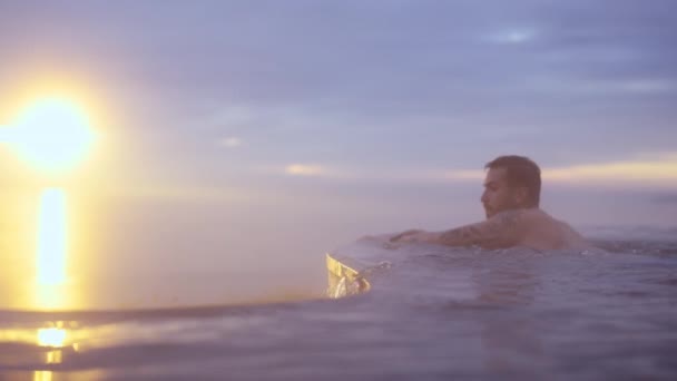 Tiro de tirar o fôlego de banho de casal na piscina infinita contra céu crepúsculo ensolarado — Vídeo de Stock