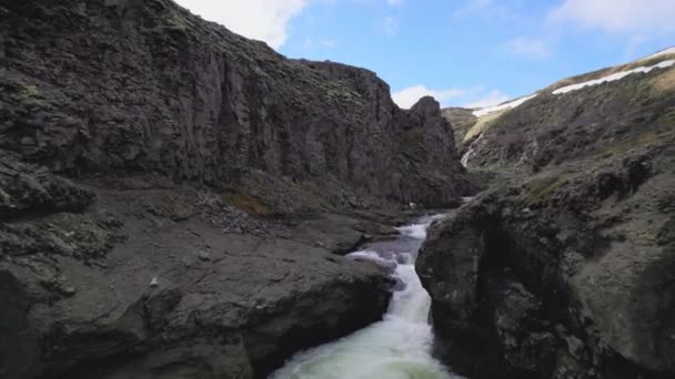 Cascate tra le montagne con macchie di neve sotto il cielo blu — Video Stock