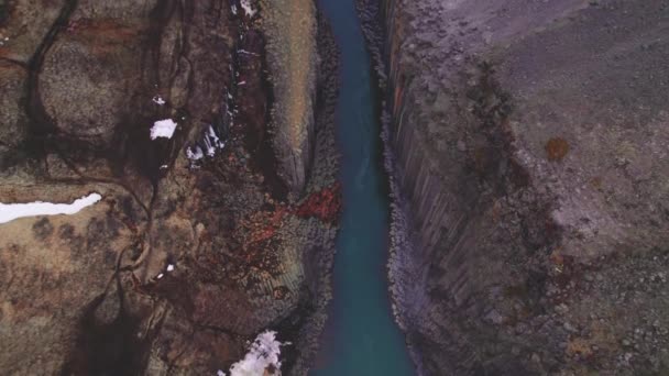 Modrá ledovcová řeka obklopena čedičovými skalními sloupy a jasnou oblohou — Stock video