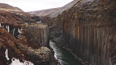 Bazalt Kaya Sütunları ve Parlak Gökyüzü ile Mavi Buzul Nehri