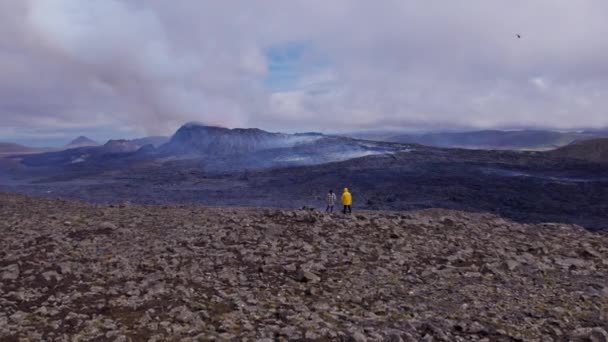 Kitört vulkán bátor utazókkal a Rocky Field tetején Izlandon — Stock videók