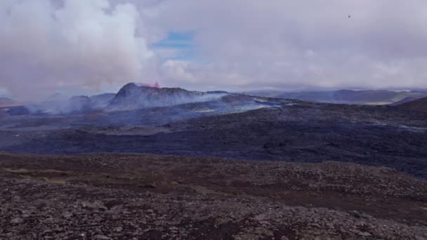 Wallpaper View of an Erupting Volcano, Travelers, a Vast Rocky Field — Stock Video