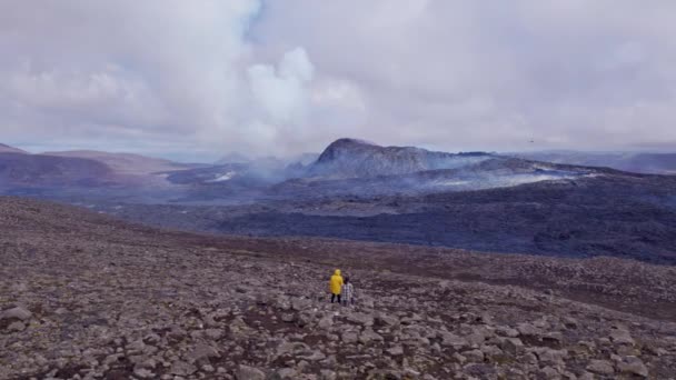 Drone Shot of Mountain Ranges, dois turistas parados no Rocky Vast Field — Vídeo de Stock