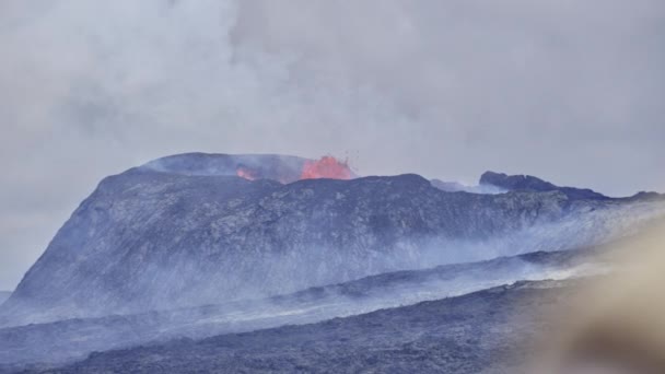 Cierre el disparo constante de un volcán en erupción mientras libera magma en su cráter — Vídeos de Stock