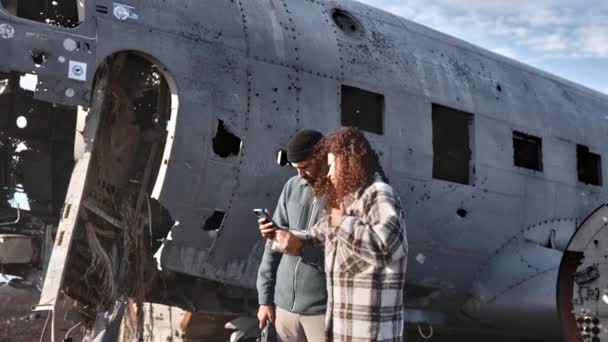 Mittlerer Zoom Aufnahme eines schönen Paares vor dem Flugzeugwrack von Solheimasandur — Stockvideo