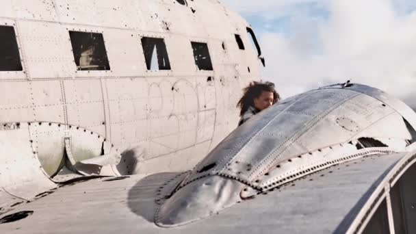 Adembenemend schot van mooi vrouwelijk model genieten van de buitenkant van vliegtuig wrak — Stockvideo