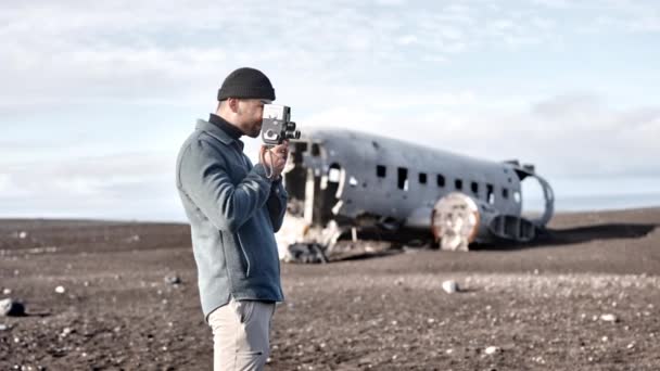 Malerische Aufnahme eines männlichen Reisenden, der das Flugzeugwrack von Solheimasandur filmt — Stockvideo