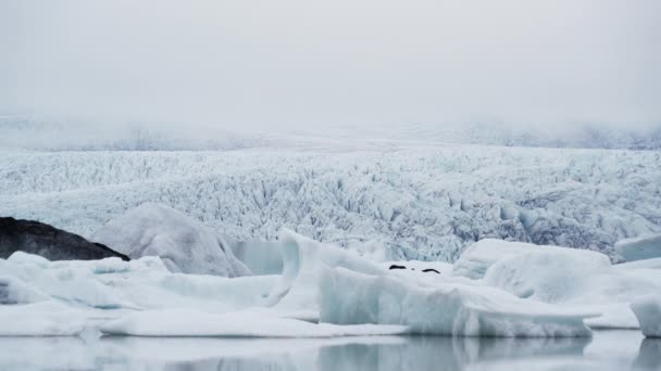 आइसलैंड में ग्लेशियल फील्ड और अग्रभूमि में शीत झील का स्थिर शॉट — स्टॉक वीडियो