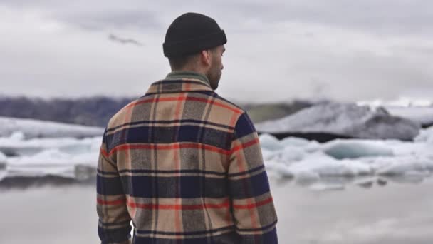 Cielos claros, lago congelado y glaciar de fusión con turista masculino en primer plano — Vídeos de Stock