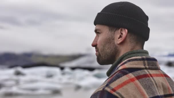 Stetige Nahaufnahme eines männlichen Reisenden, der den schmelzenden Gletscher in Island bewundert — Stockvideo