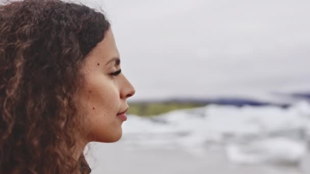 Closeup Tiro de Mulher e Céus Brilhantes e Vista Desfocada da Geleira na Islândia — Vídeo de Stock