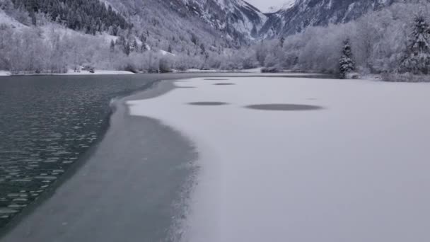 오스트리아의 클 람 제에 있는 부분적으로 얼어붙은 호수를 본뜬 드론 주 사포 — 비디오