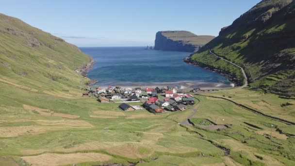 Drone shot van kleine huizen bij de oceaan wateren in Tjornuvik, Faeröer Eilanden — Stockvideo