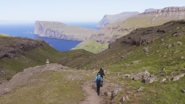 Faroe Adaları ve İki Yürüyüşçü 'de Dik Uçurumun Panoramik Görüntüsü — Stok video