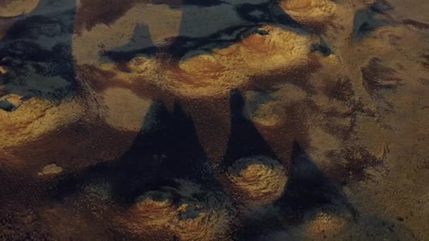 Krásné letecké záběry kráterů na poli a vyvýšené skály tvořící stíny — Stock video