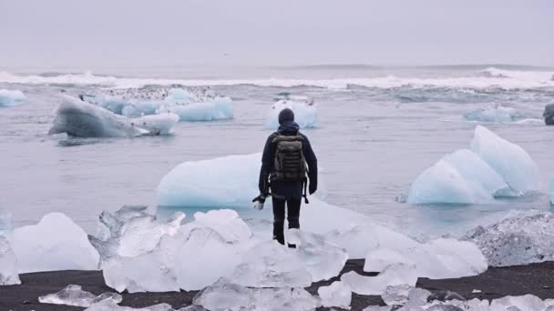 Fotograaf op onderzoek naar Diamond Beach bij gletsjerlagune van IJsland — Stockvideo