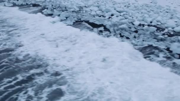 Drone πάνω από τη θάλασσα και Diamond Beach κοντά στη λιμνοθάλασσα παγετώνα της Ισλανδίας — Αρχείο Βίντεο