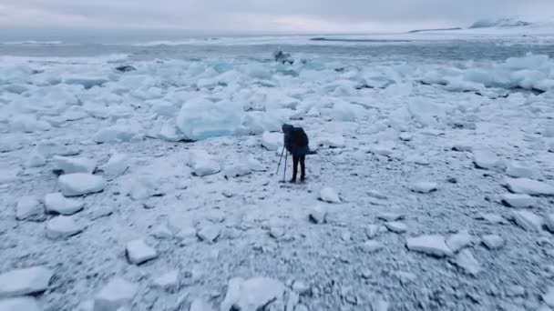 Drone over fotograaf op Diamond Beach bij gletsjerlagune van IJsland — Stockvideo