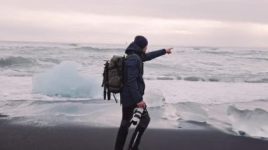 İzlanda 'da elmas plajı boyunca yürüyen fotoğrafçı.