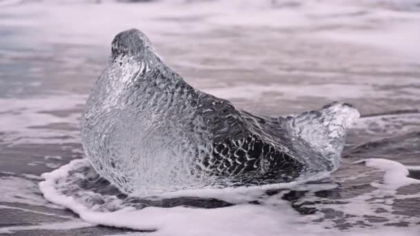 アイスランドの氷河湖の近くのダイヤモンドビーチの海水と氷 — ストック動画