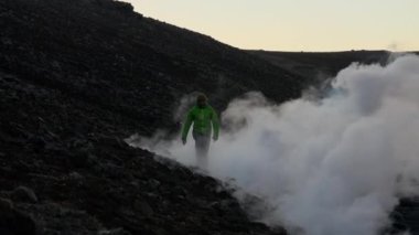 Lavın dumanından yükselen adam Fagradalsfall Volkanı 'ndan fışkırıyor.