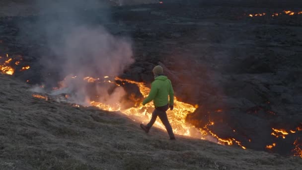 Muž kráčející podél toku Lávy z erupce Fagradalsfjall sopky na Islandu — Stock video