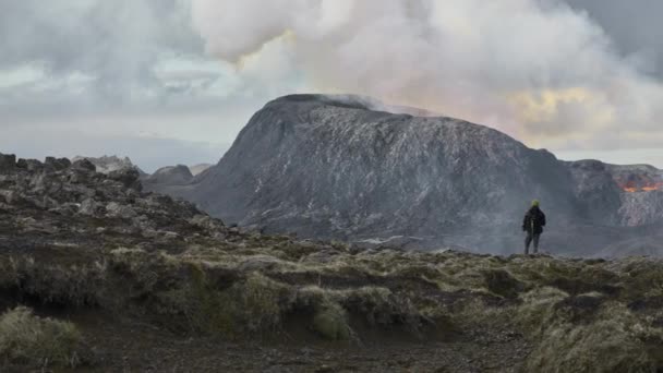 Homem observando o fluxo de lava de romper o vulcão Fagradalsfjall na Islândia — Vídeo de Stock