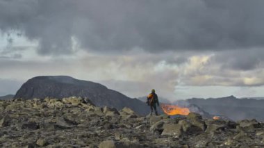 İzlanda 'daki volkanik patlamadan lavların akışını izleyen adam.