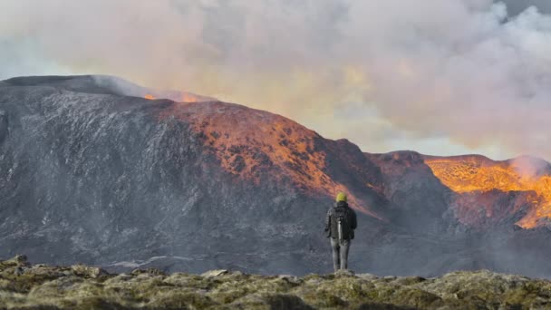 Homem caminhando em direção à erupção do vulcão Fagradalsfjall na Península de Reykjanes — Vídeo de Stock