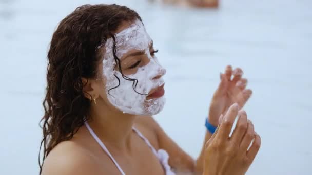Kvinna med lera ansikte mask Avslappnande i lagunen — Stockvideo