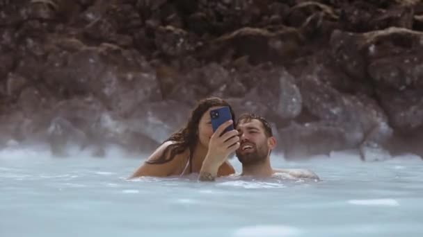 Relaxační pár Posing For Selfie In Lagoon Geothermal Spa — Stock video
