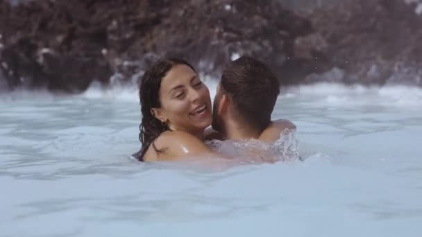 ラグーンで抱き合って笑っている若いカップル — ストック動画