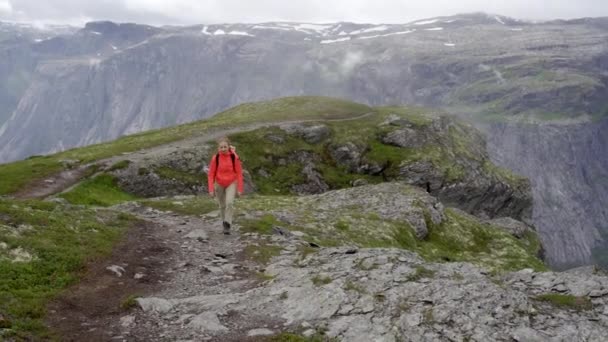 Caminante caminando sobre el pico de la montaña rocosa — Vídeos de Stock