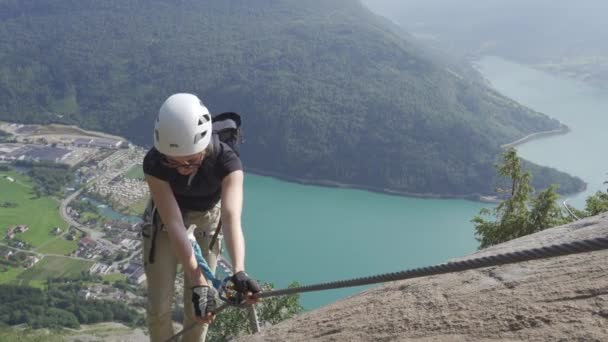 Mujer escalador escalada cumbre de montaña con cuerda — Vídeo de stock