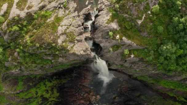 Drone sobre cachoeira em cascata sobre penhasco para o rio — Vídeo de Stock