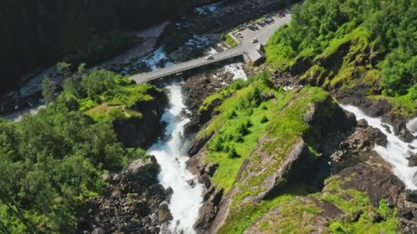 Dron nad mostem nad kaskadową wodą w dół Mountainside — Wideo stockowe