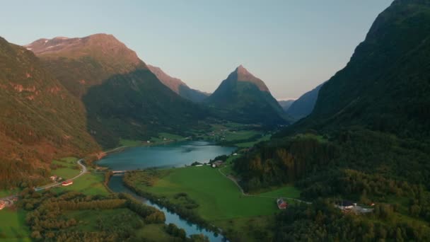 Drone sobre el valle con el lago y las montañas soleadas — Vídeos de Stock