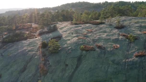 Lot dronem o wschodzie słońca nad alpinistą na zboczu góry — Wideo stockowe